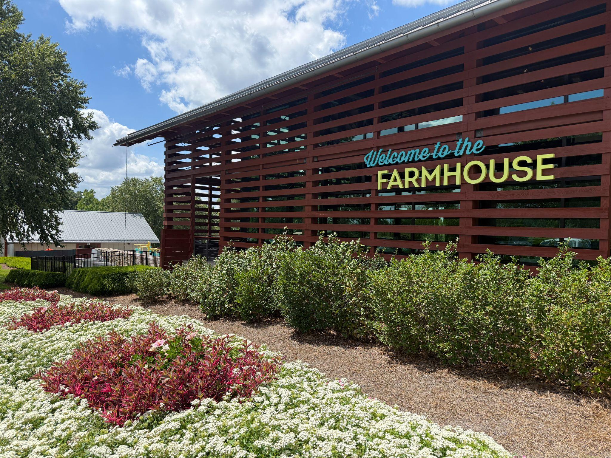 Landscaped garden beside the "Welcome to the Farmhouse" sign at The Farmhouse at Wendell Falls