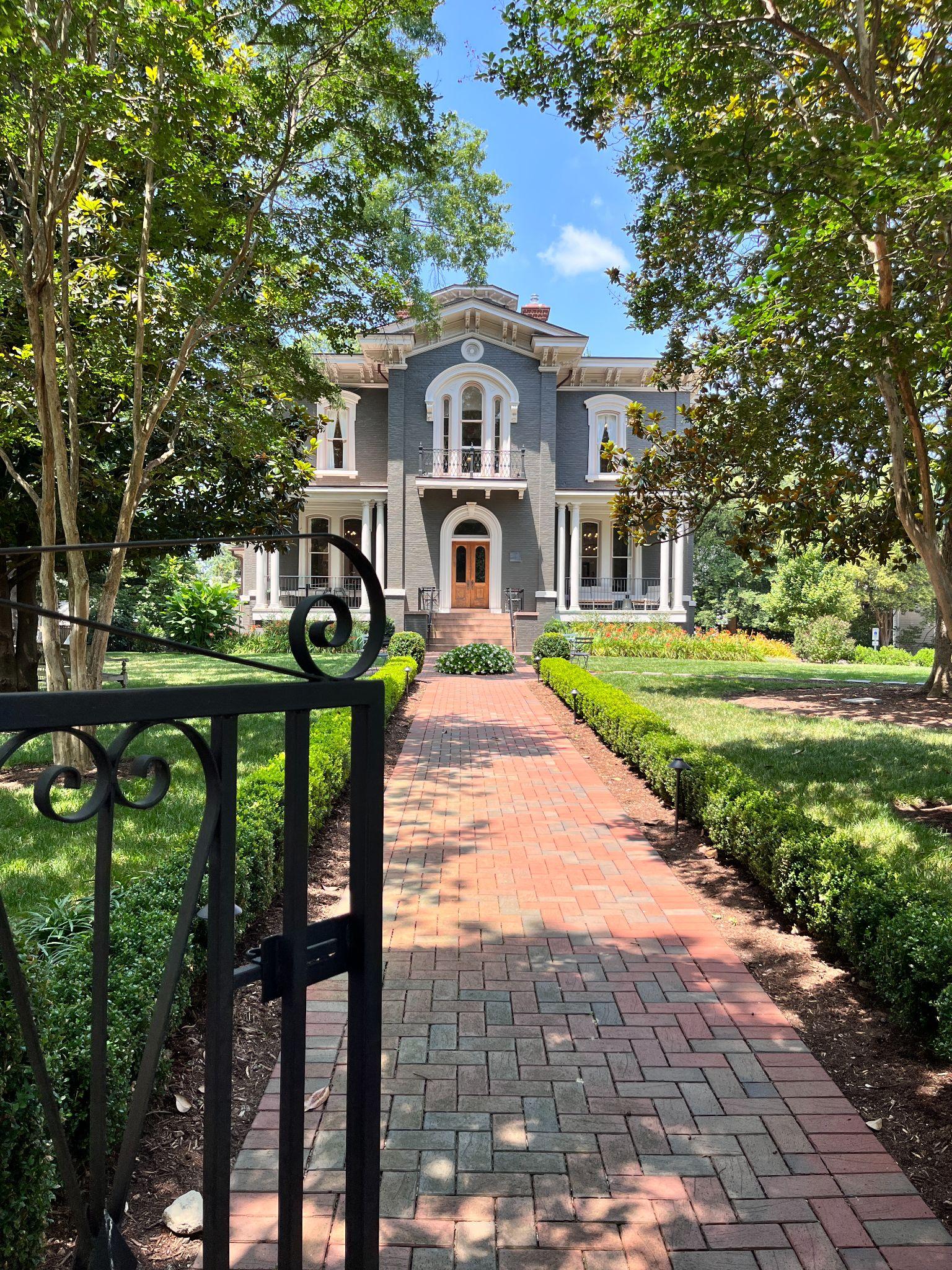 Historic Italianate mansion housing Heights House Hotel in Boylan Heights, with a brick walkway leading to the front entrance