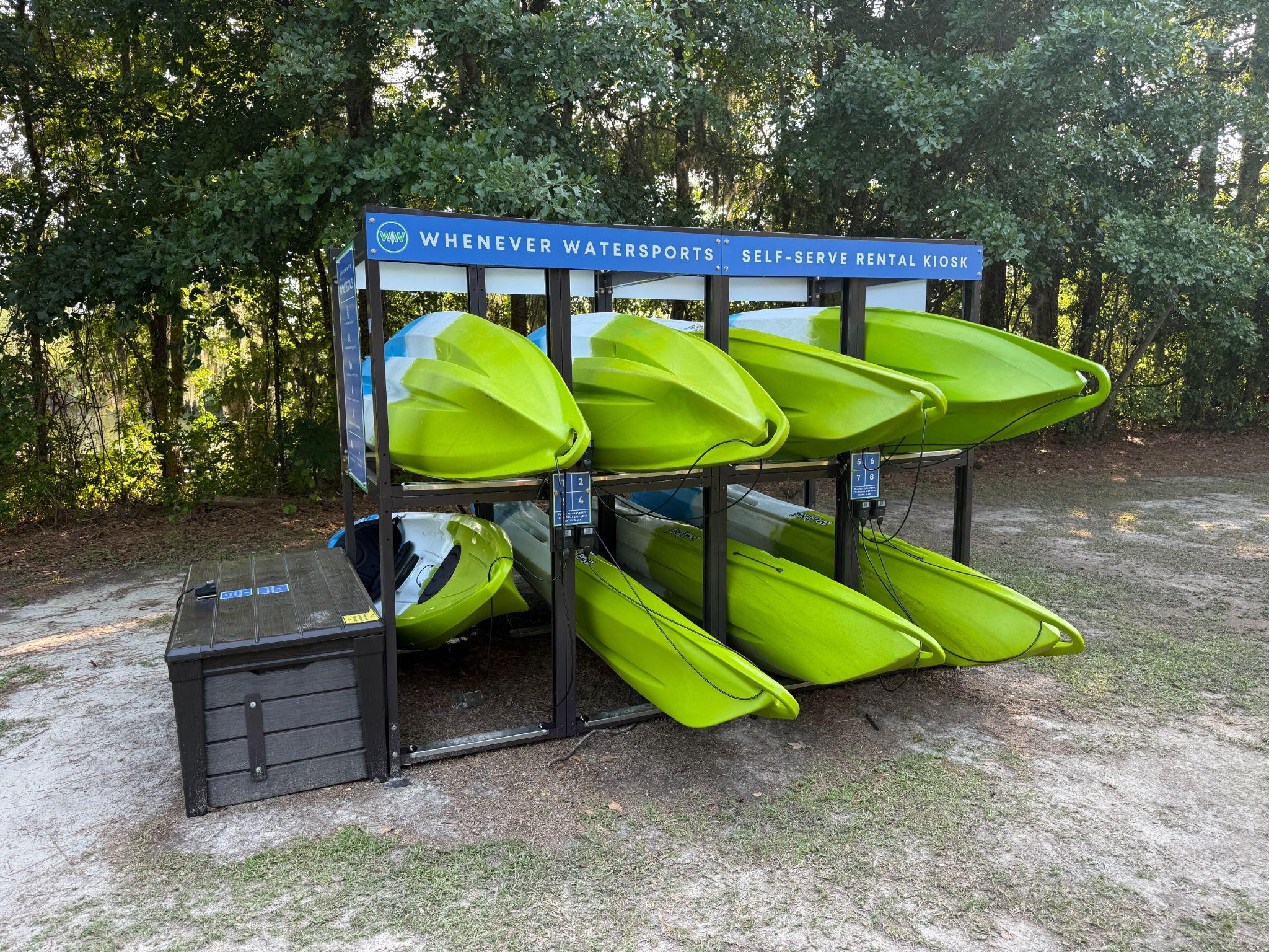 Whenever Watersports self-serve kayak rental kiosk at Creekside Park stocked with bright green kayaks