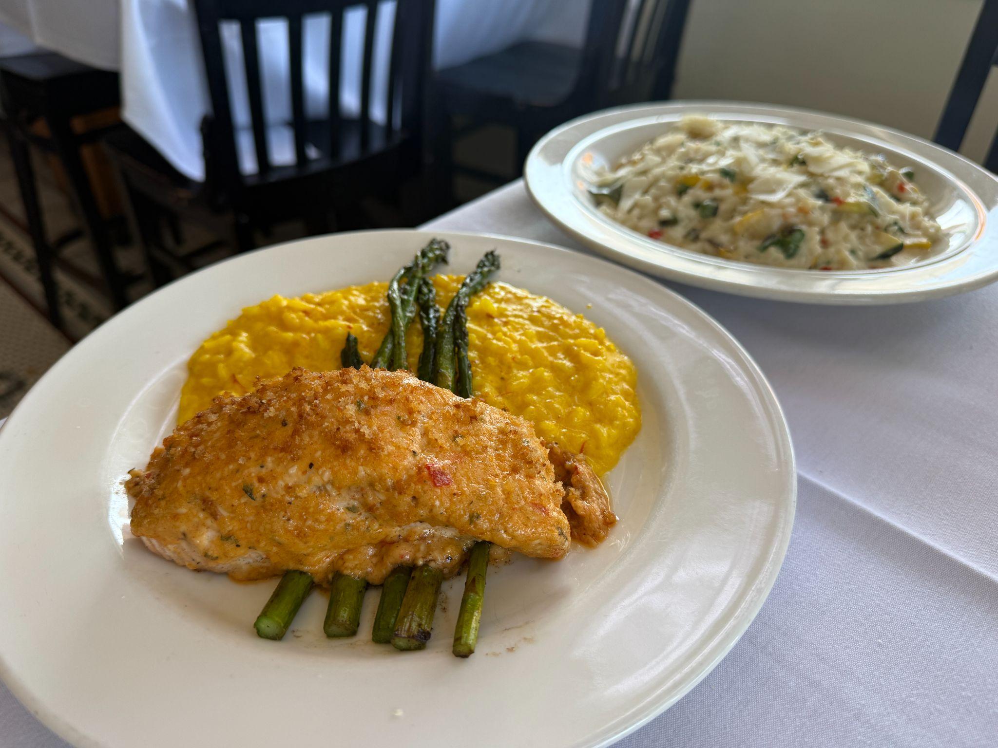 Crab-crusted fish over saffron risotto with asparagus at a New Bern restaurant, with a crab risotto in the background
